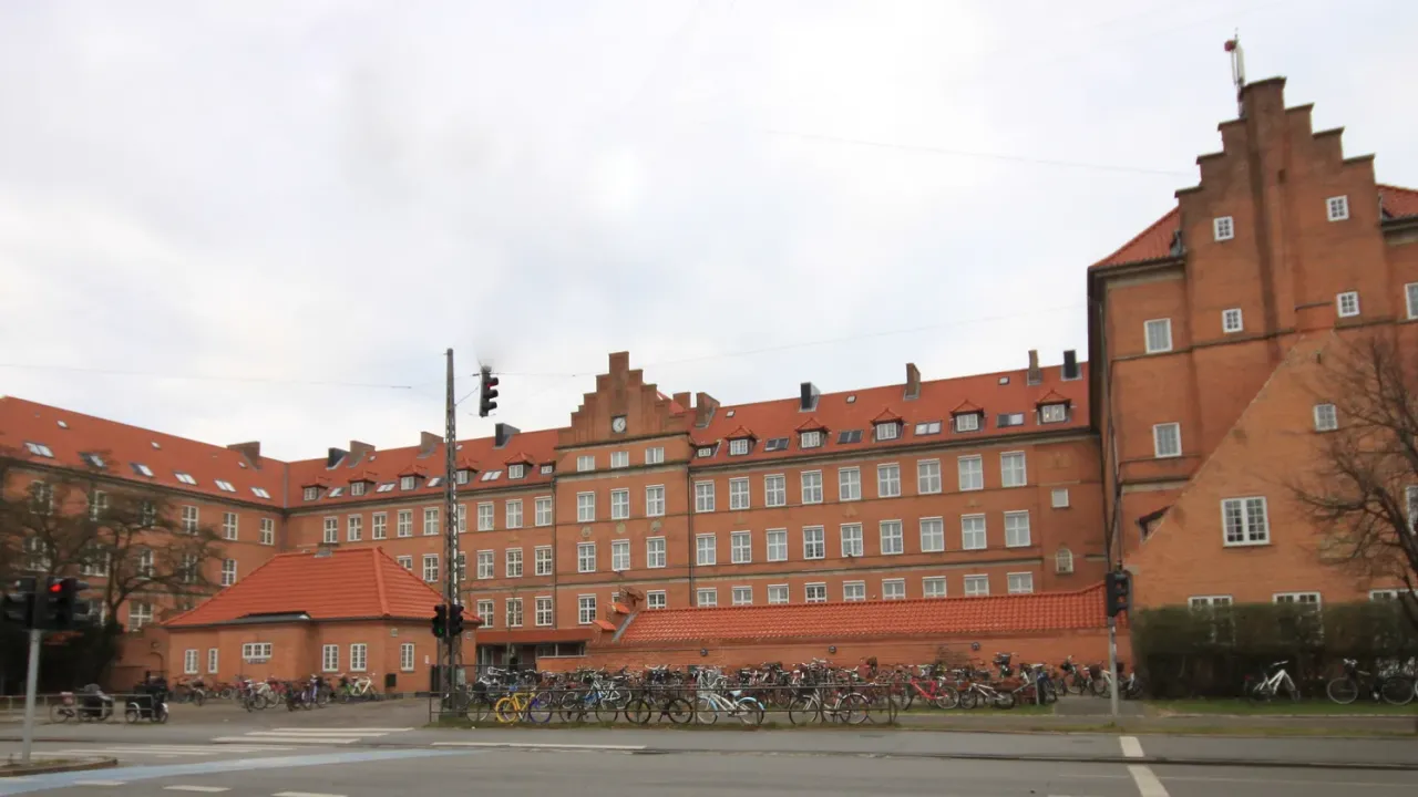 Nyboder Skoles lange røde murstensfacade med cykler langs Øster Voldgade i København.