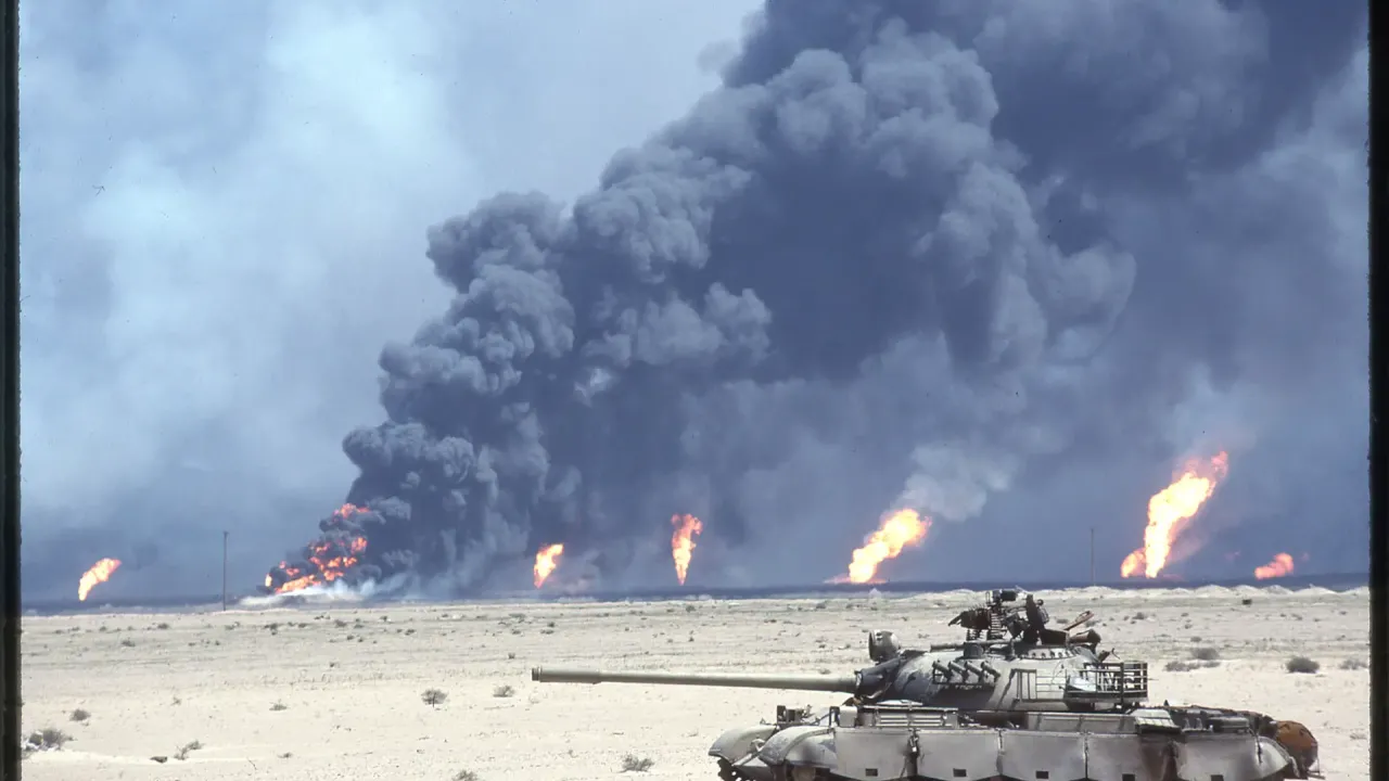 En beskadiget irakisk T-55-kampvogn foran brændende oliebrønde og sort røg i Kuwait den 12. marts 1991.