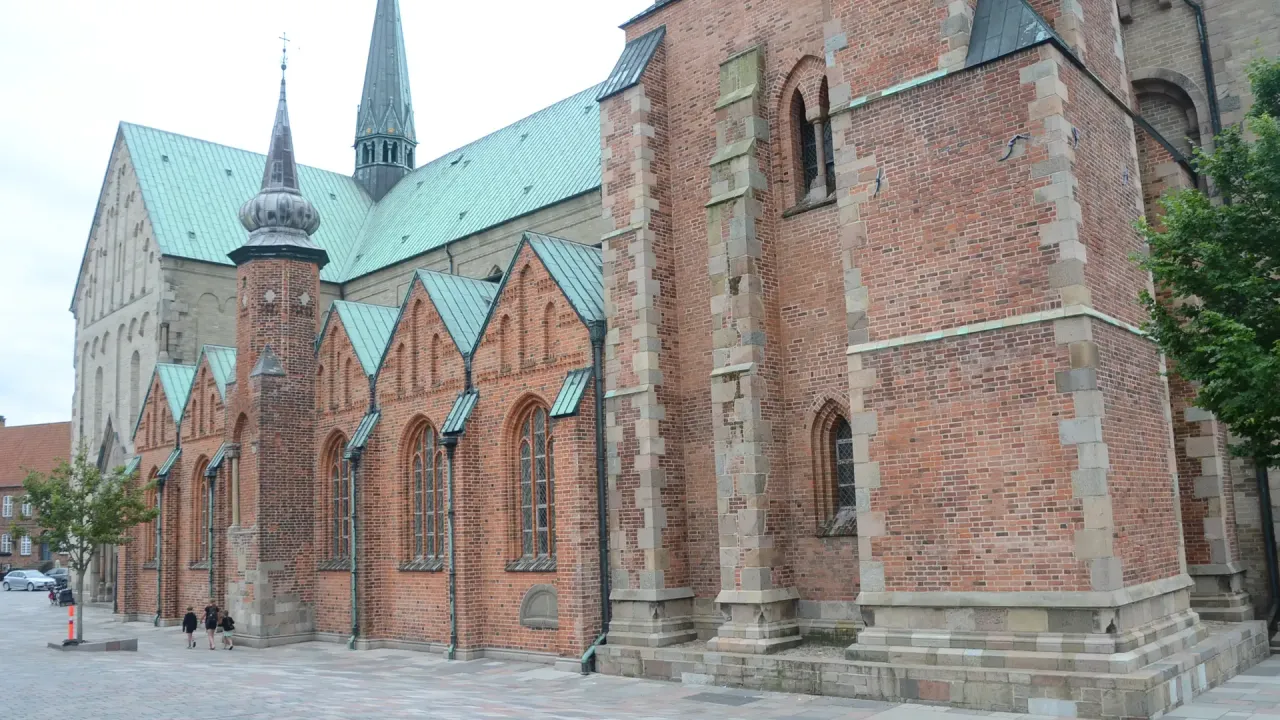Ribe Domkirke set fra nordvest med røde murstenskapeller, lyse stenmure og grønne kobbertage.