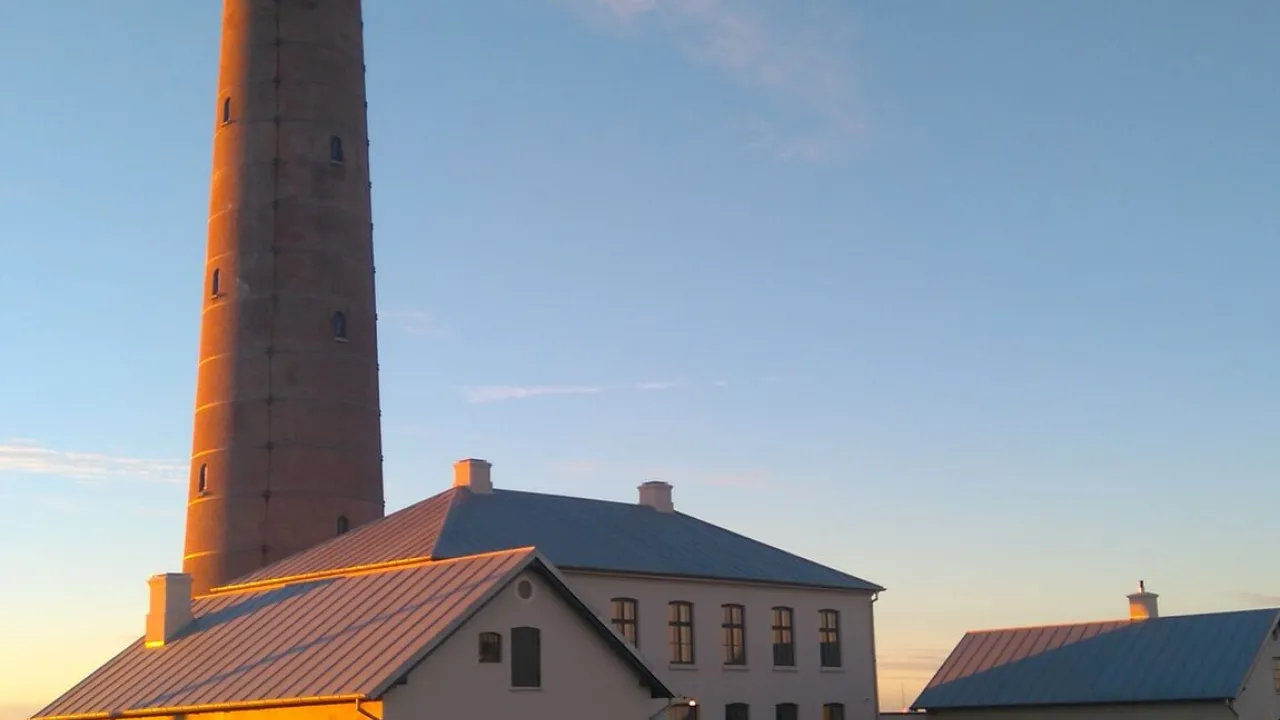Det Grå Fyr i Skagen med fyrboligerne i varmt aftenlys.