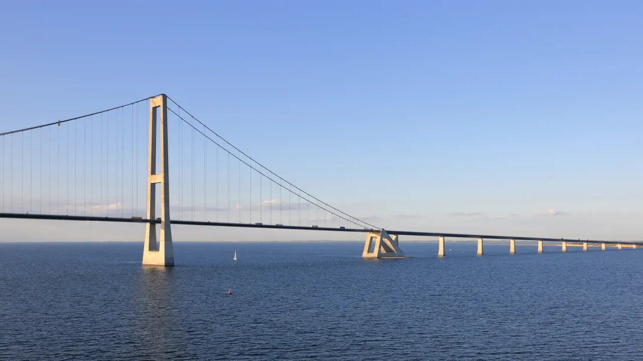 Storebæltsforbindelsens østbro i lavt sollys med en høj pylon og vejbanen over havet.