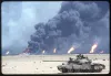 En beskadiget irakisk T-55-kampvogn foran brændende oliebrønde og sort røg i Kuwait den 12. marts 1991.