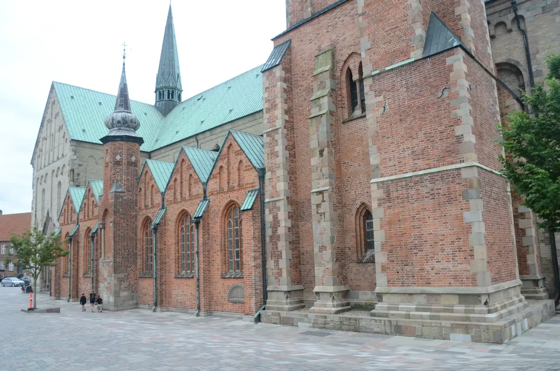Ribe Domkirke set fra nordvest med røde murstenskapeller, lyse stenmure og grønne kobbertage.