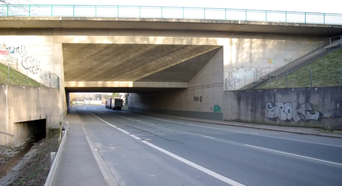 En vej under Main-Donau-Kanalen med rækker af små dæksler i asfalten.