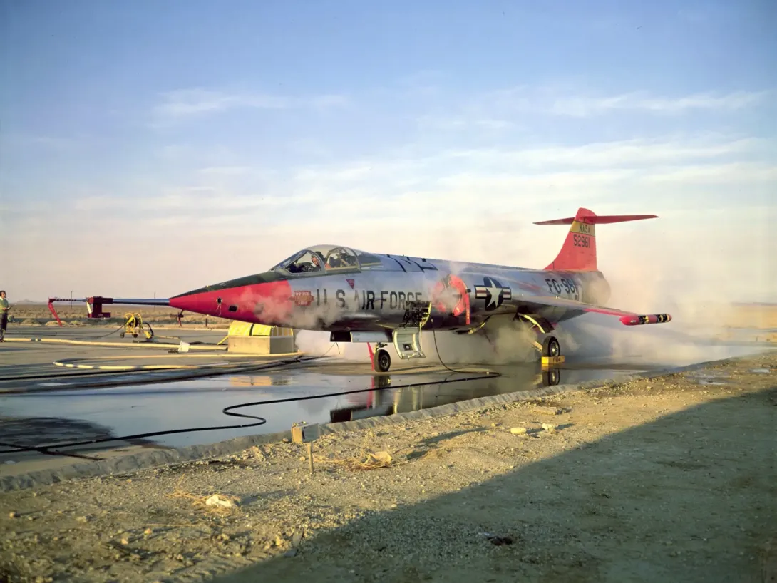 NASA-flyet JF-104A på jorden under test af reaktionskontrollen med synlige hvide gasfaner omkring flyet.